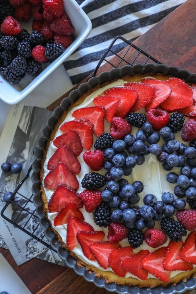 A cake with fruit on top of a wooden table