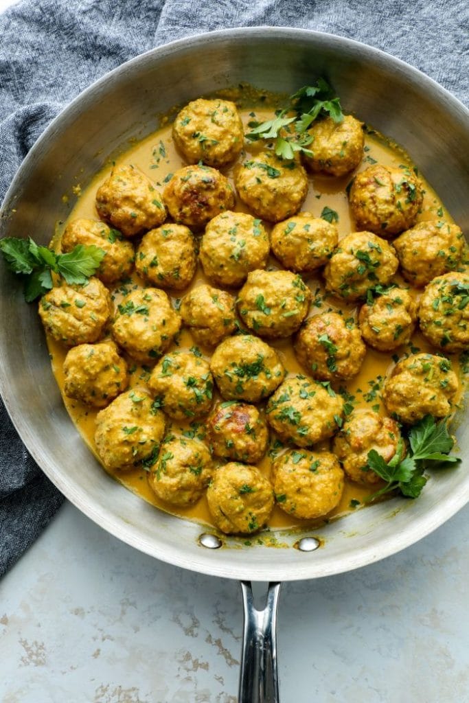 Low Carb Butter Chicken Meatballs in a pan on a grey towel.