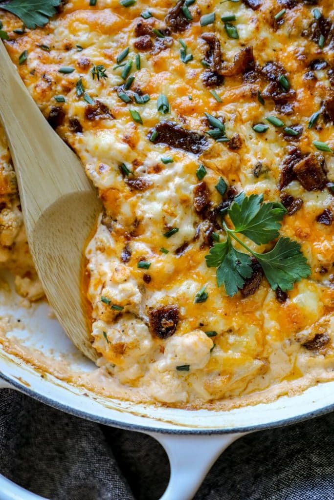 Smoked Bacon Cauliflower Mac and Cheese with a wooden spoon in it.