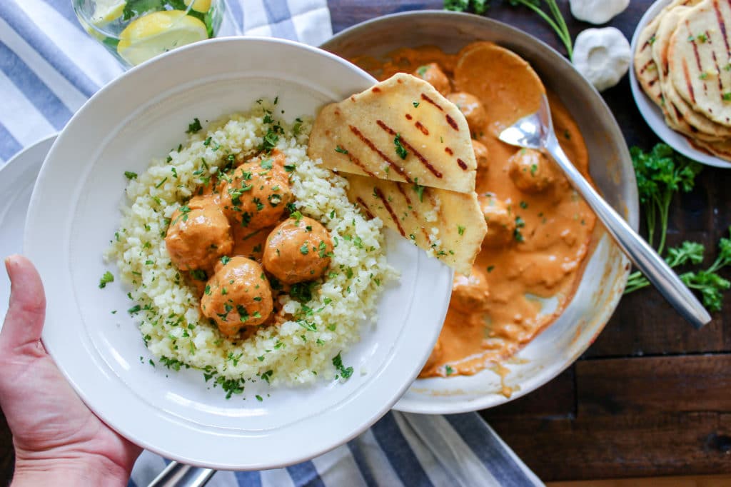 A plate of food on a table, with Flatbread and Naan