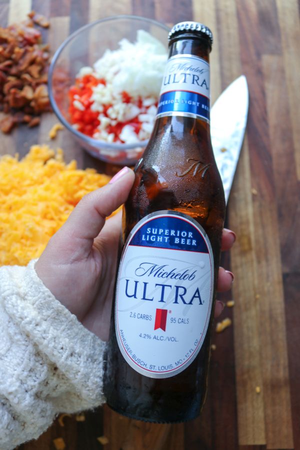 woman's hand holding a michelob ultra beer