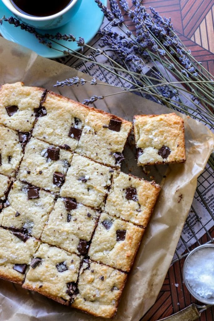 Sliced keto blondies on a table with a cup of coffee