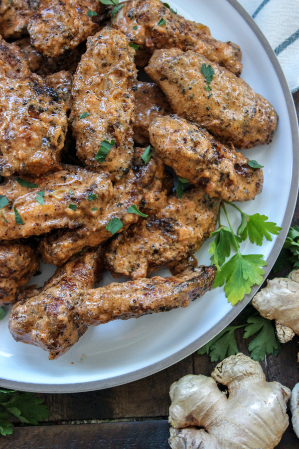 A plate of food, with butter chicken hot wings.