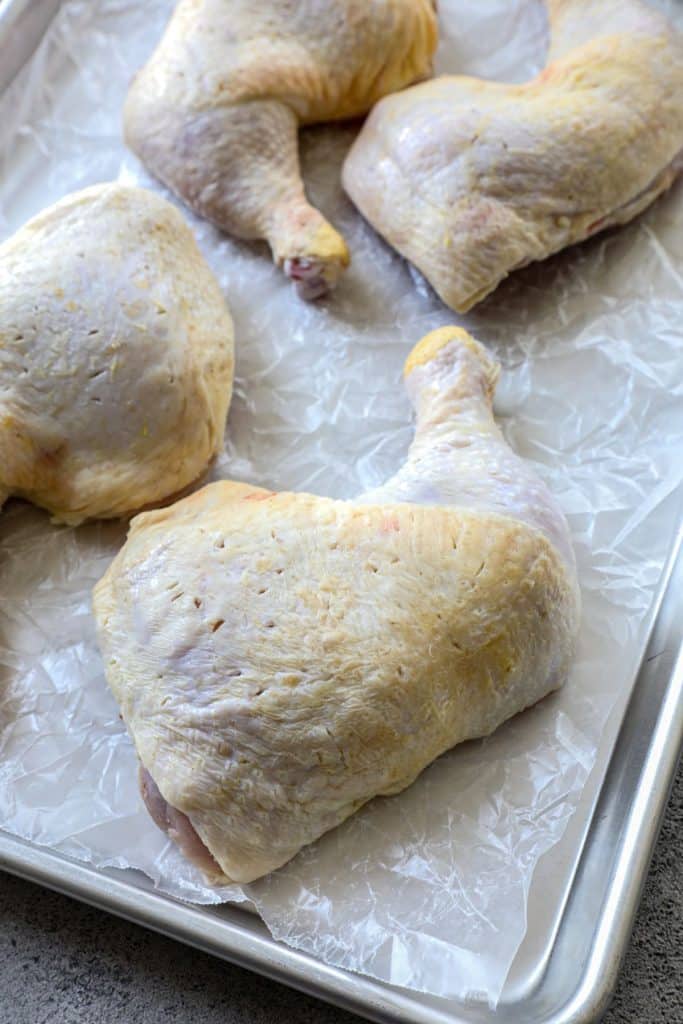 A raw chicken quarter showing a thigh and drumstick 