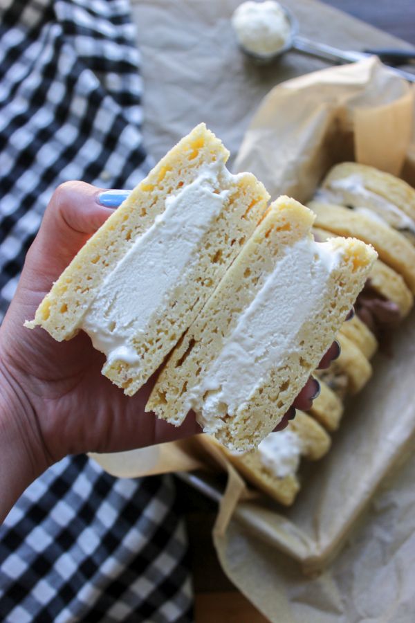 A halved keto ice cream sandwich being held by a hand. 