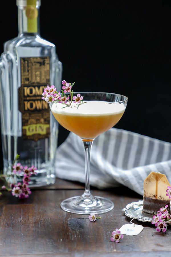 Keto earl grey gin fizz cocktail on a brown table.