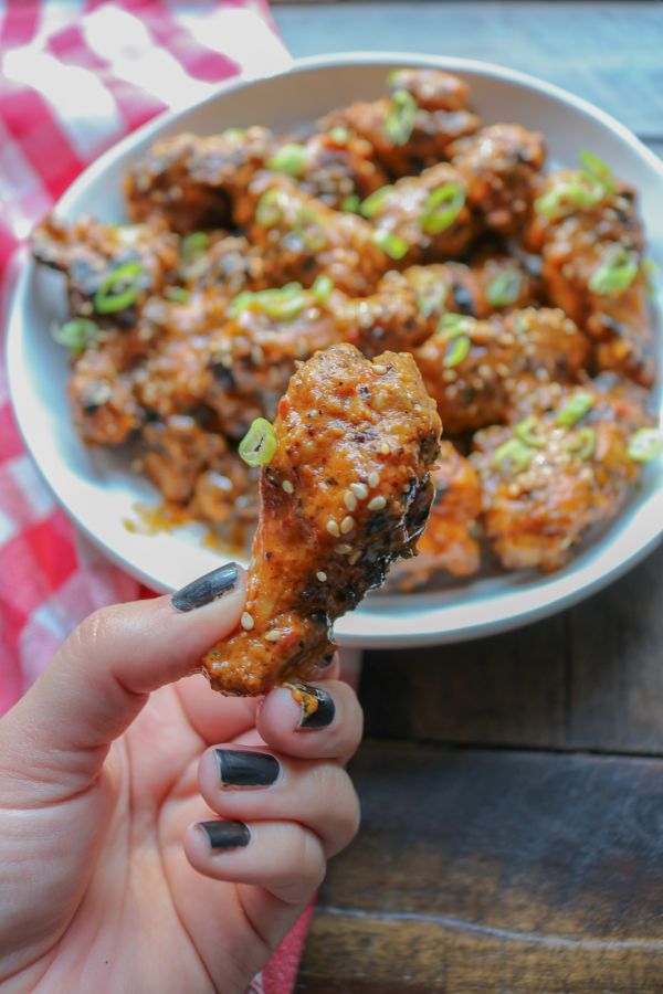 cooked thai spicy chicken wing in a hand
