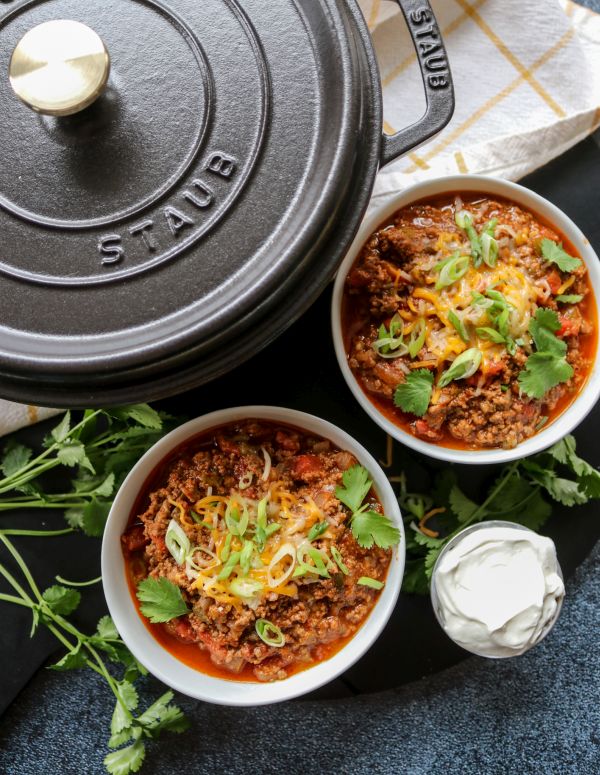 Two bowls of beef chili and a large black pot