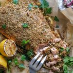 Pistachio salmon on a platter being cut with a fork