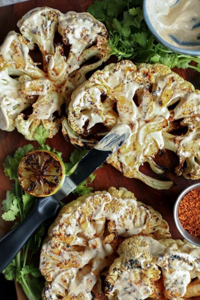Assembling the elote cauliflower steaks.