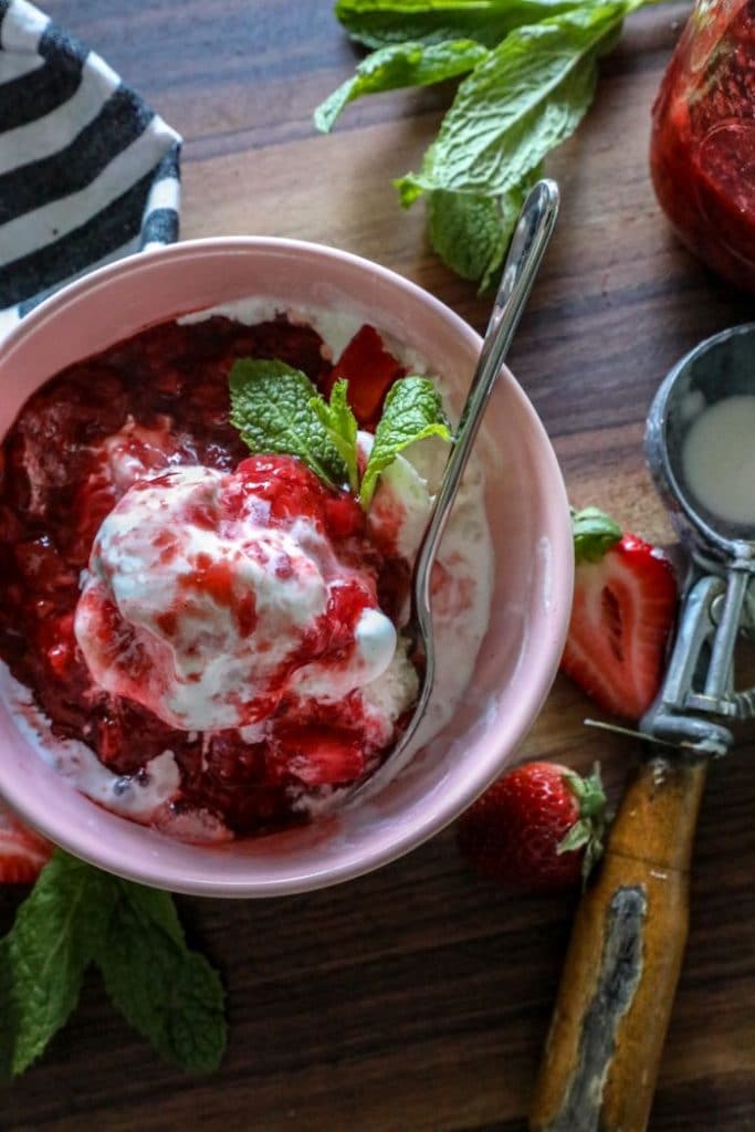 A plate of food on a wooden table, with Strawberry sauce