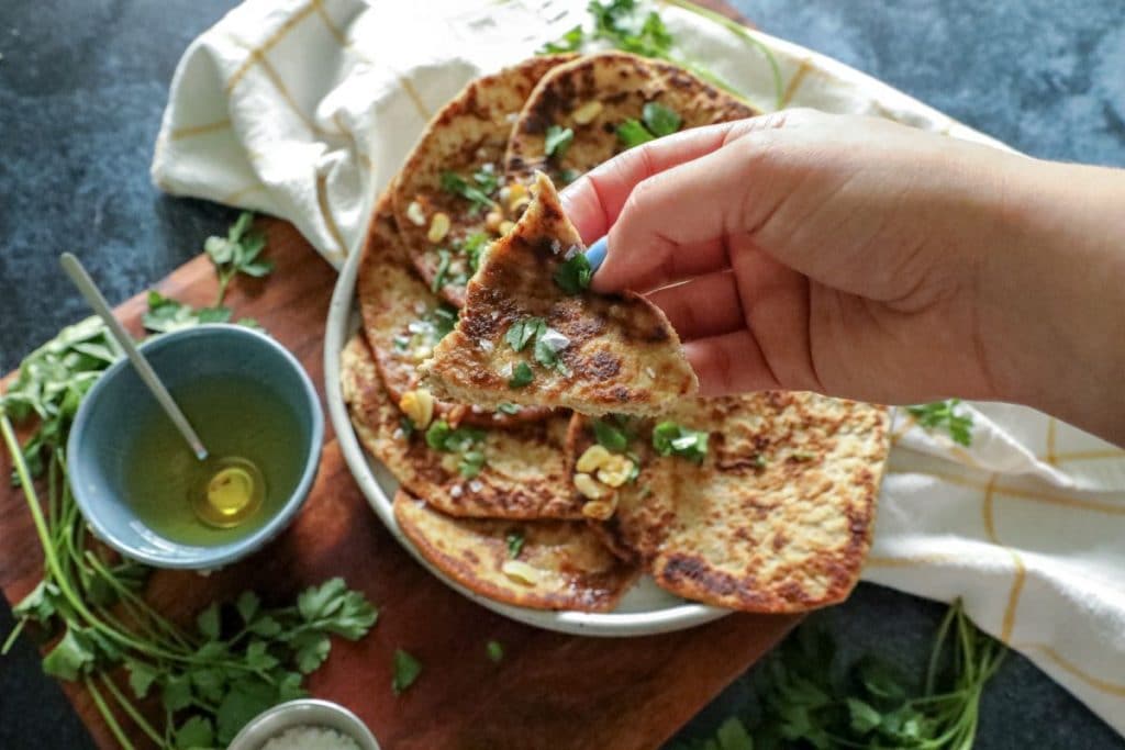 A torn piece of the flatbread in hand