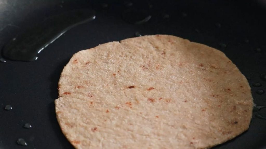 Piece of flatbread cooking in a frying pan