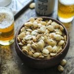 Smoked Marcona almonds in a bowl on tray with beer