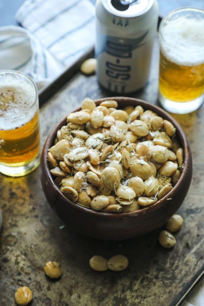 Smoked Marcona almonds in a bowl on tray with beer