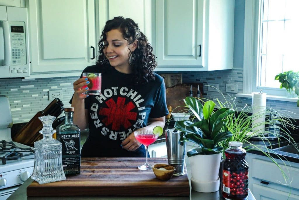 A girl holding a cosmopolitan cocktail.