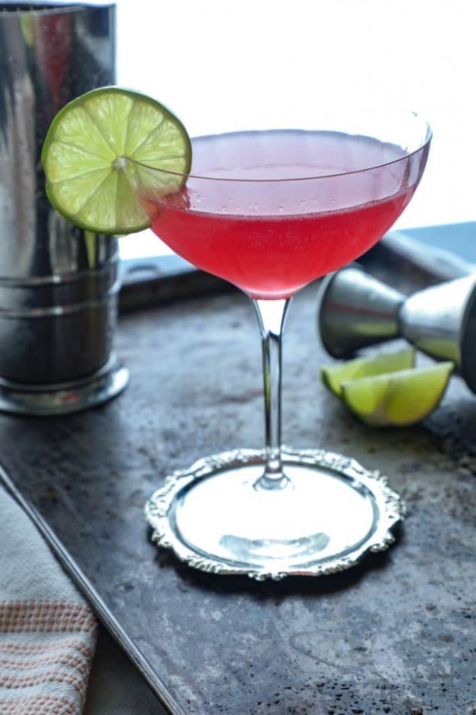 A close up view of the traditional low carb cosmopolitan in a coupe glass with a lime wheel garnish.