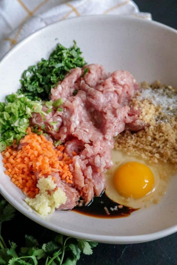 A bowl of food with meat and vegetables to make egg roll meatballs