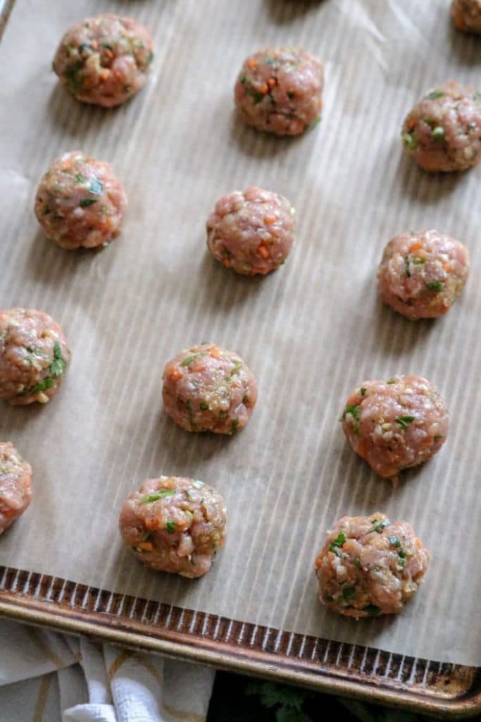 Rolled out meatballs on a pan