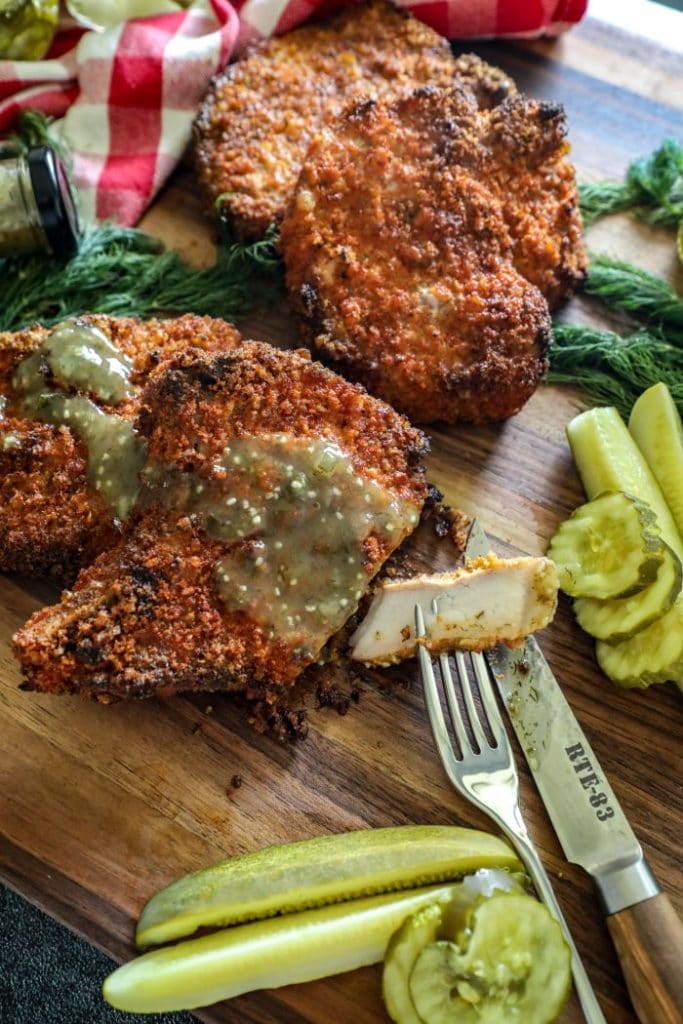 Smoked Dill Pickle Brined Pork Chops served with dill pickle hot sauce and cut into. 