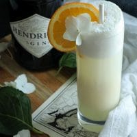 Keto Creamsicle Gin Fizz on a board with a white towel and a bottle in the background.
