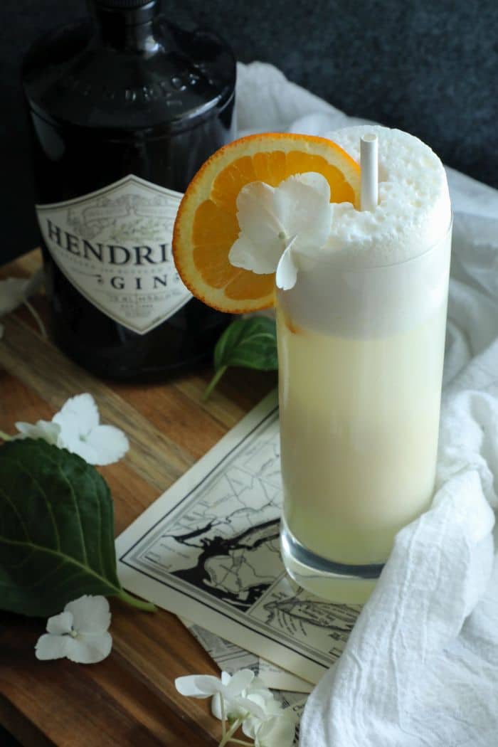 Keto Creamsicle Gin Fizz on a board with a white towel and a bottle in the background.