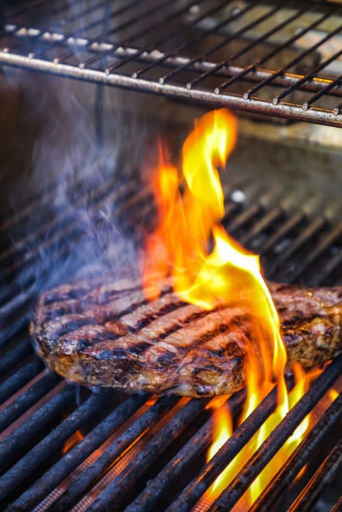 A ribeye for steak frites being seared on the grill.