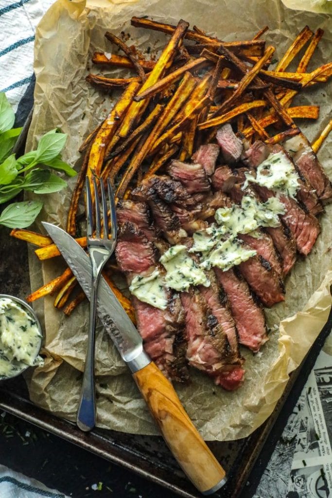 Sliced ribeye keto steak frites with horseradish butter spread on top.