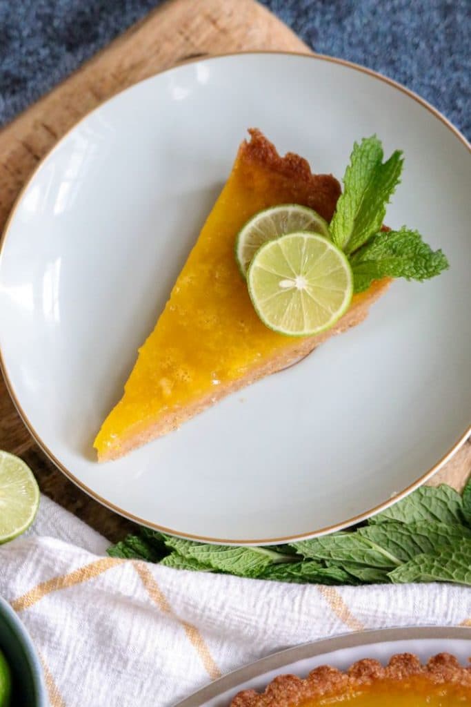 Slice of keto key lime tart on a white plate.