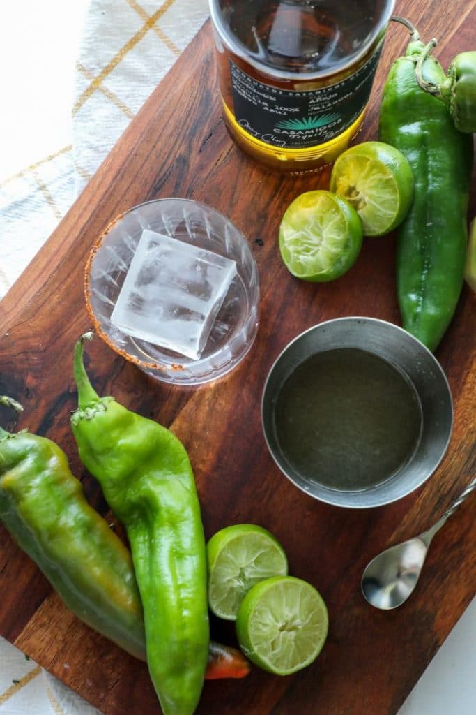 The mixed hatch chile margarita and a rocks glass with a large ice cube.