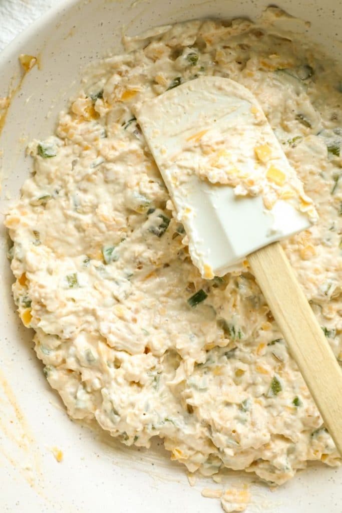 Hatch chili dip mixed together with a spatula in a white bowl. 