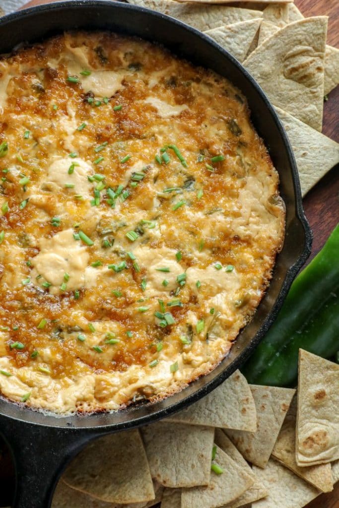 Close up of smoked hatch chili dip on a brown board.