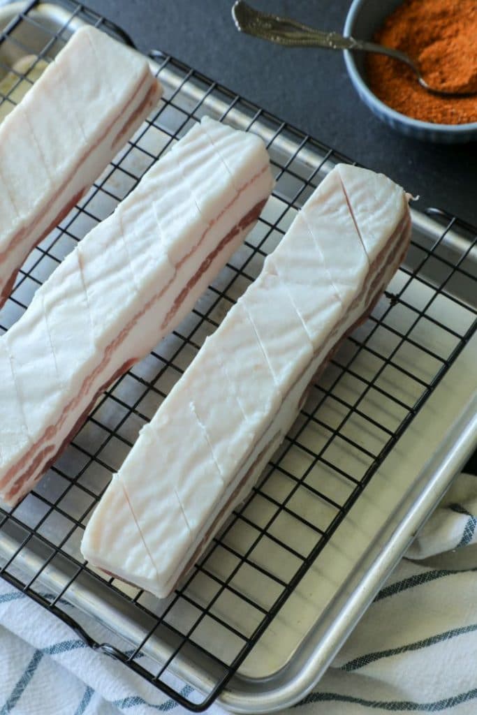 Sliced skin on the raw pork belly with seasonings in a bowl. 