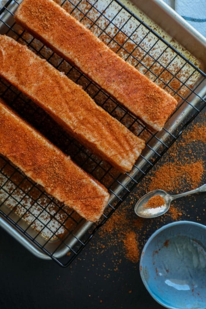 Sliced raw pork belly with all purpose BBQ rub on it.