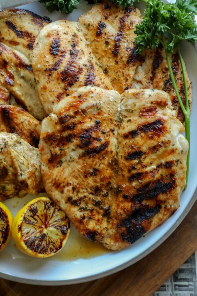 A platter of perfectly grilled chicken breasts on a plate.