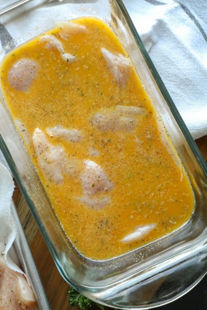 Raw chicken soaking in a marinade.