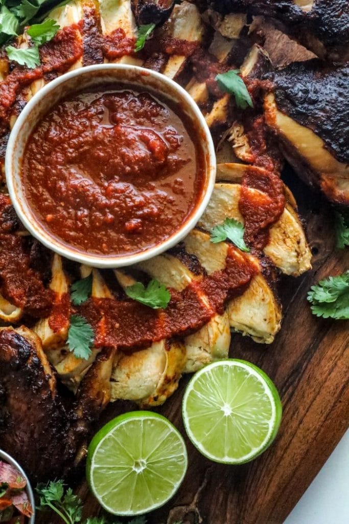 Grilled Spatchcock Chicken Tinga sliced on a cutting board