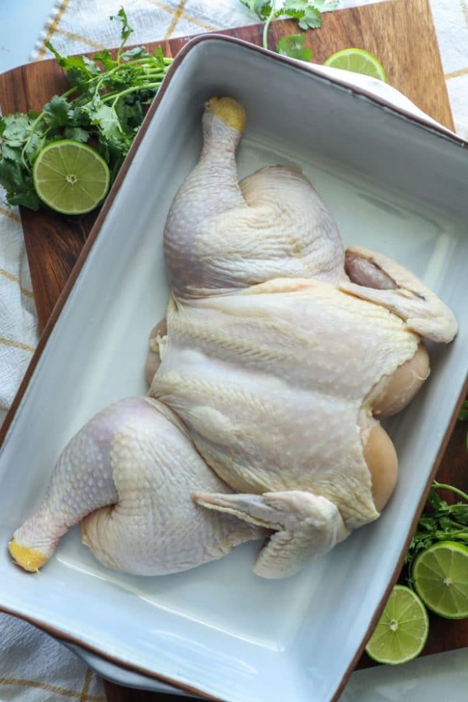 Raw chicken prepped in the spatchcock fashion.