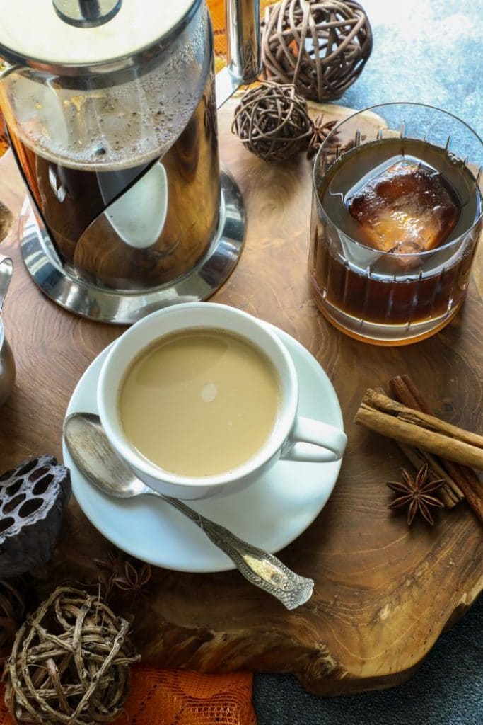 Keto Pumpkin Spice Simple Syrup with hot and cold coffee on a wood platter.