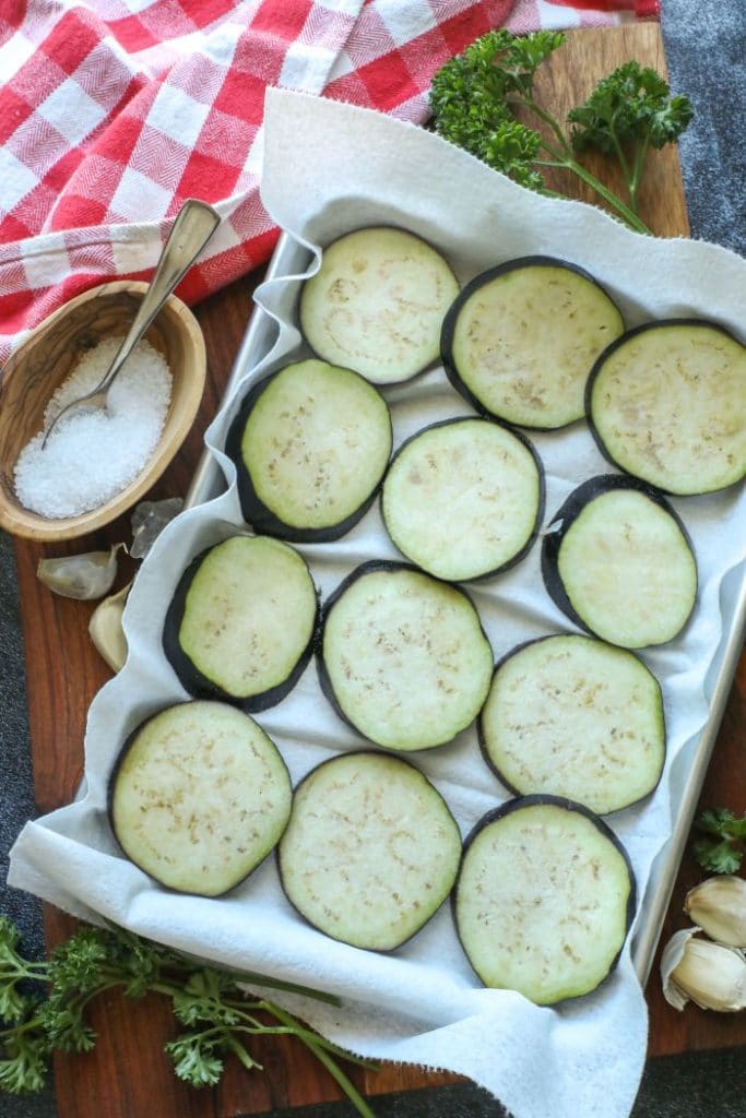 Sliced eggplant rounds onto a paper towel lined baking sheet.