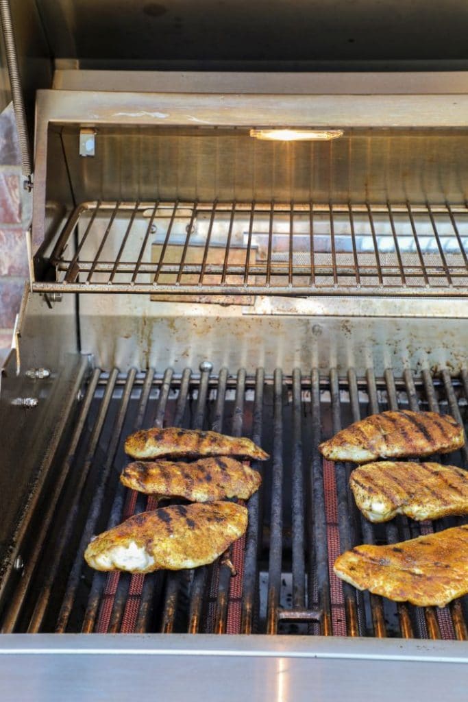 Curry chicken cooking on a grill.