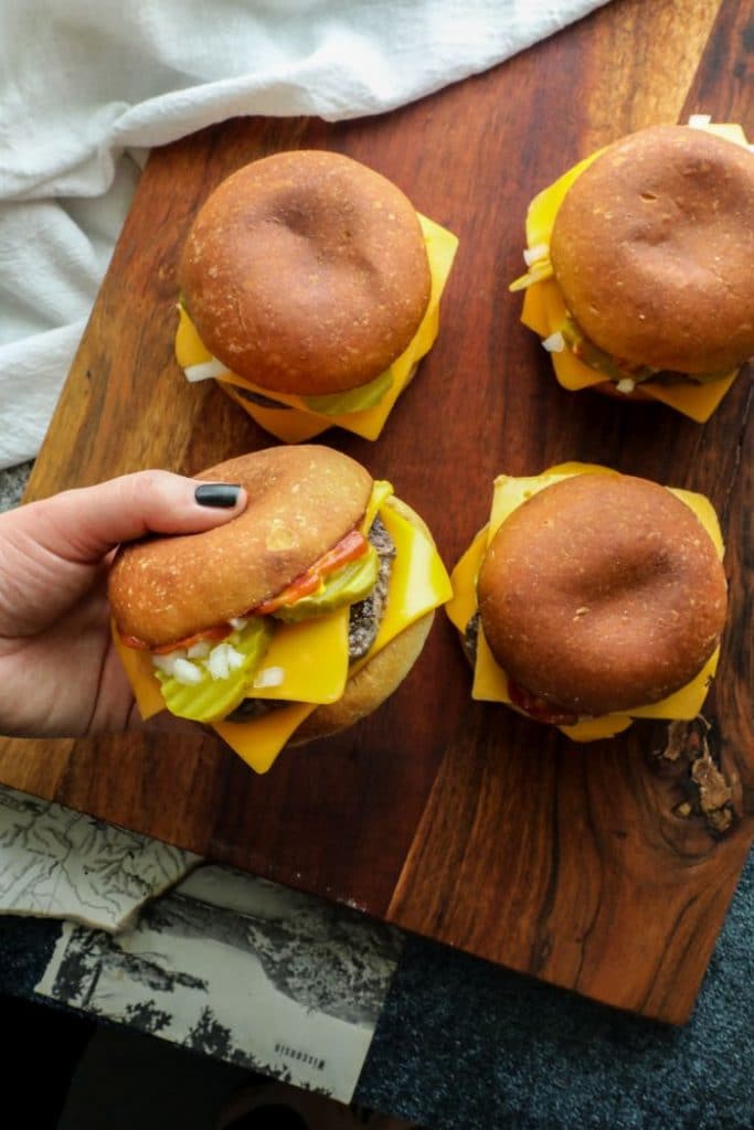 Homemade Keto Quarter Pounders on a brown cutting board.