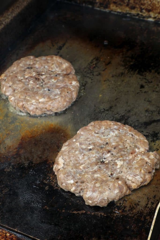 Searing the homemade quarter pounder on a griddle.