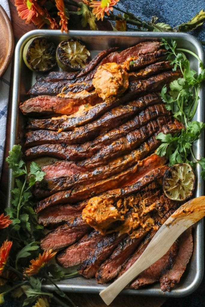 Easy Grilled Adobo Marinated Flank Steak sliced thin with chipotle butter on top