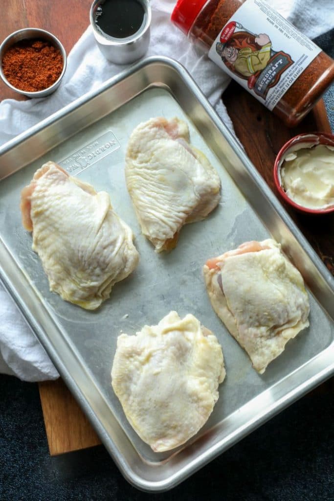 Raw chicken thighs with BBQ rub and maple syrup