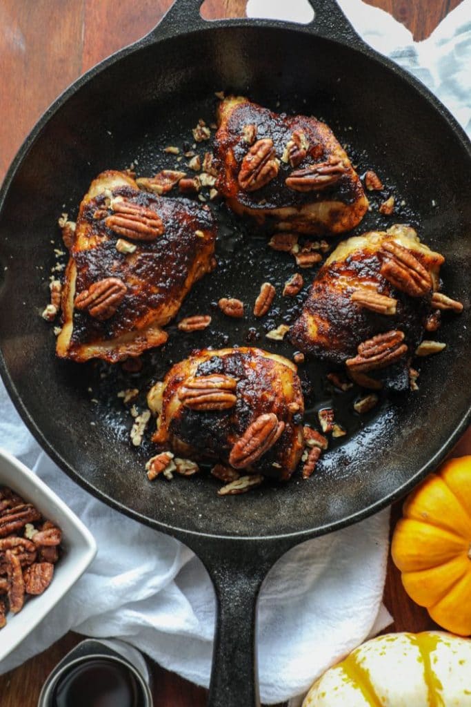 Grilled Crispy Maple Pecan BBQ Chicken Thighs in a skillet
