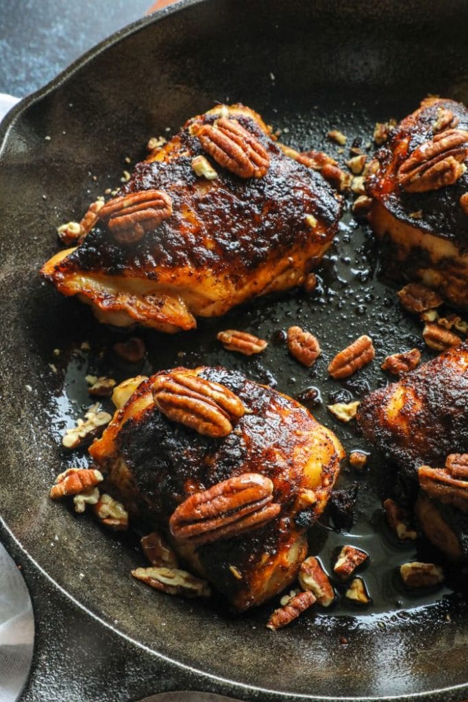 Grilled Crispy Maple Pecan BBQ Chicken Thighs in a skillet