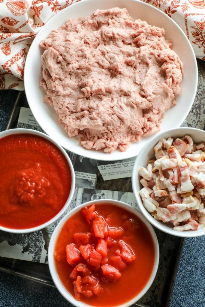 Ground turkey, bacon, and tomatoes in bowls.