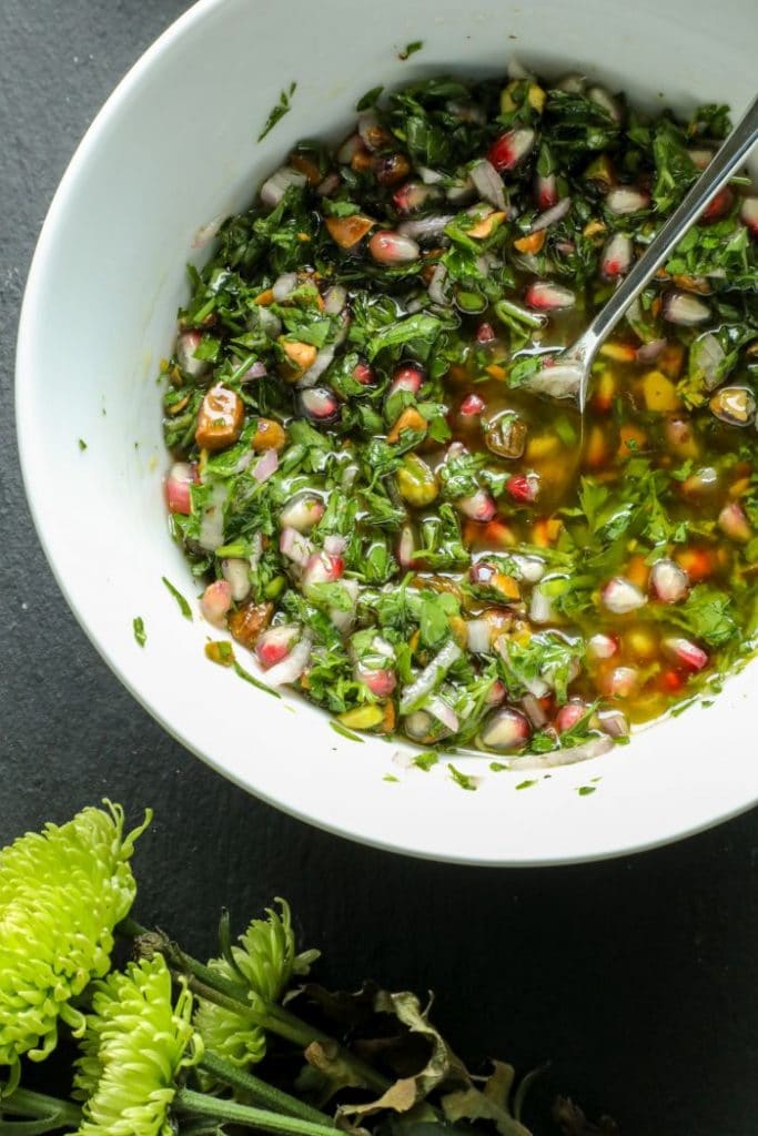 Pistachio and pomegranate chimichurri in a white bowl.