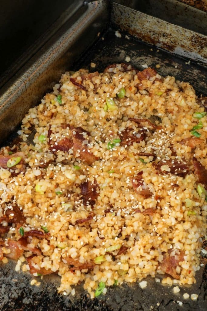 Easy Bacon Cauliflower Fried Rice being cooked in a griddle pan
